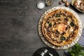Delicious quiche with mushrooms and ingredients on dark grey table, flat lay. Space for text Royalty Free Stock Photo