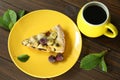 Delicious Quiche pie with cherry filling on yellow plate with cup of coffe