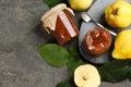 Delicious quince jam and fruits on grey table, flat lay