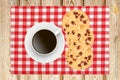 Delicious raisins and chocolate cake with cup of coffee on napkin over wooden background Royalty Free Stock Photo