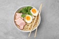 Delicious ramen with meat on light grey table, top view. Noodle soup