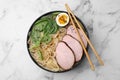 Delicious ramen with meat on white marble table, top view. Noodle soup