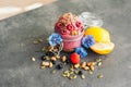 Delicious raspberry ice cream with pumpkin seeds and hempseed, decorated with blue cornflowers, black currant, sliced lemon on Royalty Free Stock Photo