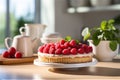 Delicious raspberry tart with cream in a beautiful cozy white kitchen on a sunny day