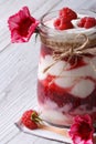 Delicious raspberry yogurt in a glass jar closeup and flowers Royalty Free Stock Photo