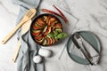 Delicious ratatouille, chili peppers and cutlery on marble table, flat lay Royalty Free Stock Photo