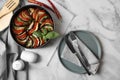 Delicious ratatouille, chili peppers and cutlery on white marble table, flat lay Royalty Free Stock Photo