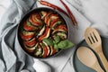 Delicious ratatouille, chili peppers, wooden spoon and spatula on white marble table, flat lay Royalty Free Stock Photo