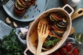 Delicious ratatouille served with basil on wooden table, flat lay