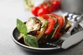 Delicious ratatouille served with basil on light grey table, closeup
