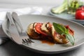 Delicious ratatouille served with basil on table, closeup