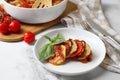Delicious ratatouille served with basil on white marble table