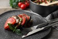Delicious ratatouille served with basil on wooden table, closeup