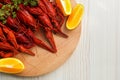 Delicious red boiled crayfish and orange on white wooden table, top view Royalty Free Stock Photo