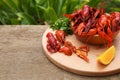 Delicious red boiled crayfish and orange on wooden table. Space for text Royalty Free Stock Photo