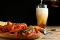 Delicious red boiled crayfishes and beer pouring into glass on background