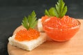 Delicious red caviar on wheat bread served with parseley on wooden desk Royalty Free Stock Photo