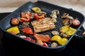 Delicious salmon and vegetables on the grill. Close-up on grilling square shape salmon, red and yellow peppers, cherry tomatoes Royalty Free Stock Photo