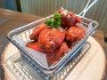 Delicious red spicy chicken wings served in stainless steel basket.