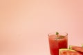 Delicious red watermelon juice with sliced fruit pieces on a plate. A sprig of mint in a glass. Copy space. Summer food concept Royalty Free Stock Photo