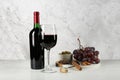 Delicious red wine, corkscrew and snacks on table against white marble background Royalty Free Stock Photo