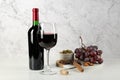 Delicious red wine, corkscrew and snacks on table against white marble background Royalty Free Stock Photo