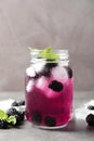 Delicious refreshing blackberry lemonade on grey table