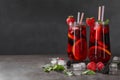 Delicious refreshing sangria, ice cubes and berries on grey table, space for text Royalty Free Stock Photo