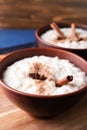 Delicious rice pudding with cinnamon and anise in bowl on wooden board, closeup Royalty Free Stock Photo