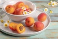 Delicious ripe apricots in a bowl on the wooden table. Close-up with apricots and daisy flowers Royalty Free Stock Photo