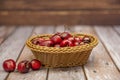 Delicious ripe cherries inside a small wicker basket on a wooden Royalty Free Stock Photo