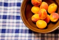 Delicious ripe fresh summer apricots in ceramic bowl on table cloth tissu white and blue background Royalty Free Stock Photo