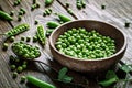 Delicious ripe green peas lying on a wooden table. Royalty Free Stock Photo