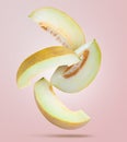 Delicious ripe melon slices falling on light pink background Royalty Free Stock Photo