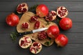 Delicious ripe pomegranates on grey wooden table, flat lay