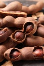 Delicious ripe tamarinds on wooden board, closeup