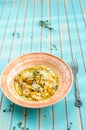 Delicious risotto with ripe pumpkin over wooden turquoise background