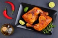 Roasted chicken legs on black plate Royalty Free Stock Photo