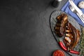 Delicious roasted ribs served on black table, flat lay. Space for text Royalty Free Stock Photo