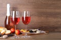 Delicious rose wine and snacks on wooden table, space for text Royalty Free Stock Photo