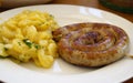 a delicious rustic Bavarian fried sausage with a potato salad