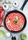 Delicious rustic raw meat sausages in frying pan, with bay leaves and fresh herbs in the kitchen Royalty Free Stock Photo