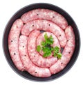 Delicious rustic raw meat sausages in frying pan, with bay leaves and fresh herbs Royalty Free Stock Photo