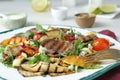 Delicious salad with beef tongue, grilled vegetables, peach, blue cheese and fork served on table, closeup