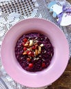 Delicious salad of berries and nuts in a pink plate against a white tablecloth, top view. AI-generated item Royalty Free Stock Photo