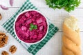 Delicious salad with boiled beets, herring, nuts, onions in a white ceramic bowl. Royalty Free Stock Photo