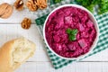 Delicious salad with boiled beets, herring, nuts, onions in a white ceramic bowl. Royalty Free Stock Photo