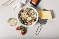 Delicious salad with fresh strawberries, red onions, herbs, goat cheese and olives. Food still life on a light background. Organic Royalty Free Stock Photo