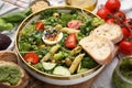 Delicious salad with pesto sauce in bowl and ingredients on table, closeup Royalty Free Stock Photo