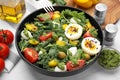 Delicious salad with pesto sauce in bowl and ingredients on white tiled table, closeup Royalty Free Stock Photo